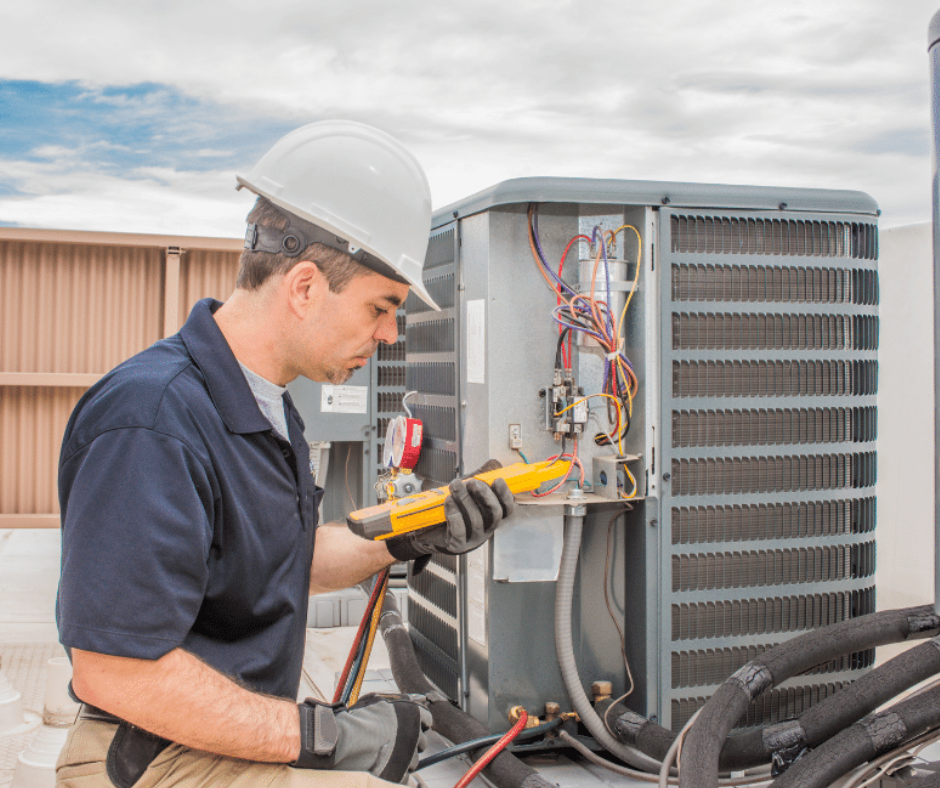 An HVAC technician checks freon levels