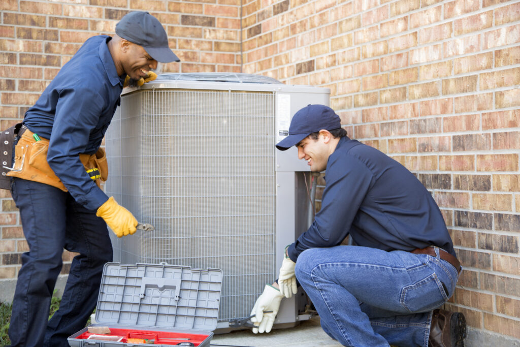 HVAC technicians installing a new outdoor AC unit